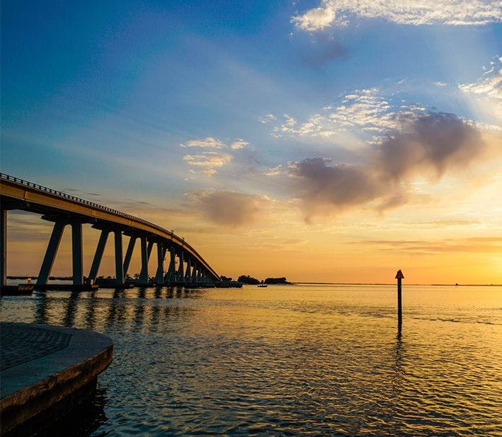 the Gulf of mexico with a bridge in sunset